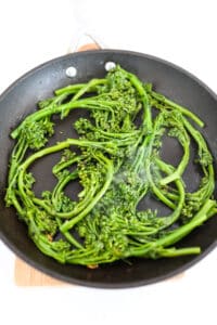 Broccolini in pan with garlic, olive oil and chili flakes.