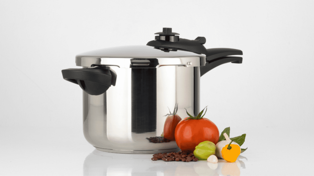 image of a shiny new pressure cooker with vegetables in front of it