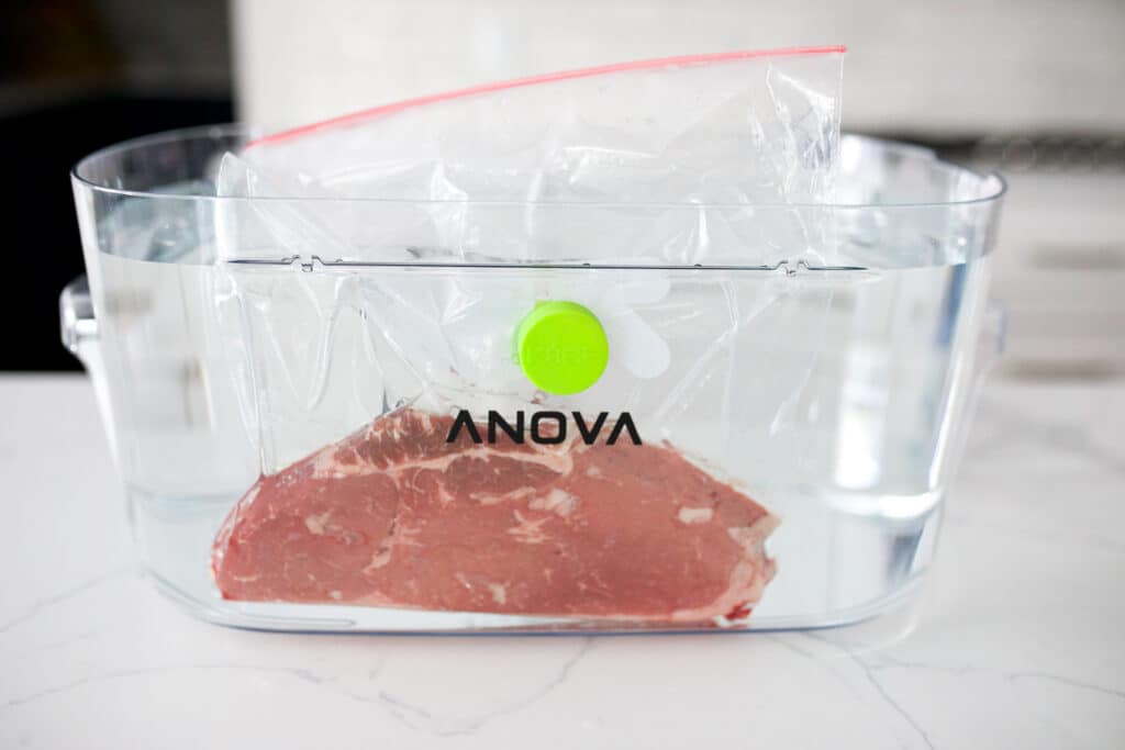 Top sirloin steak in a ziplock bag in a water bath ready to sous vide.