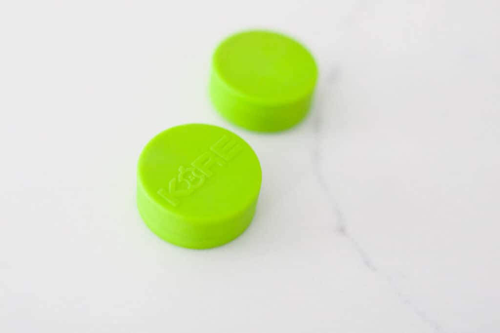 Bright green (Kore brand) magnets on a white contertop.