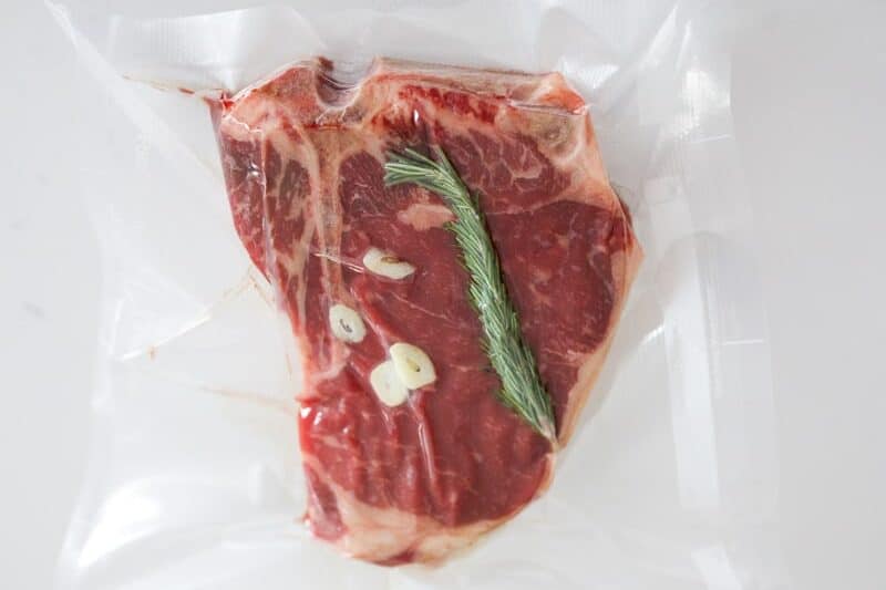 T-bone steak vacuum sealed with rosemary and garlic