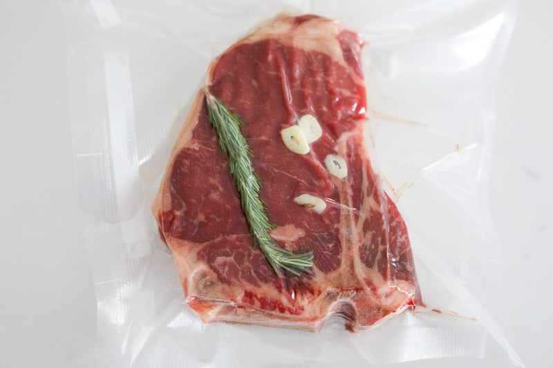 T-bone steak vacuum sealed with rosemary and garlic