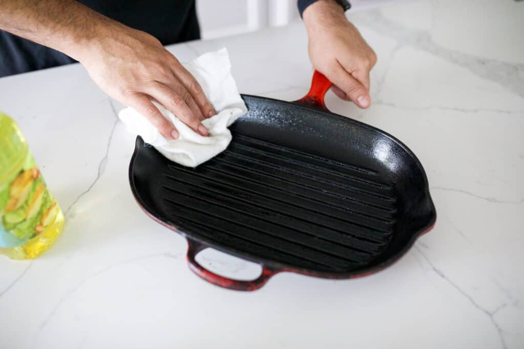 Seasoning cast iron with oil on a microfiber cloth.