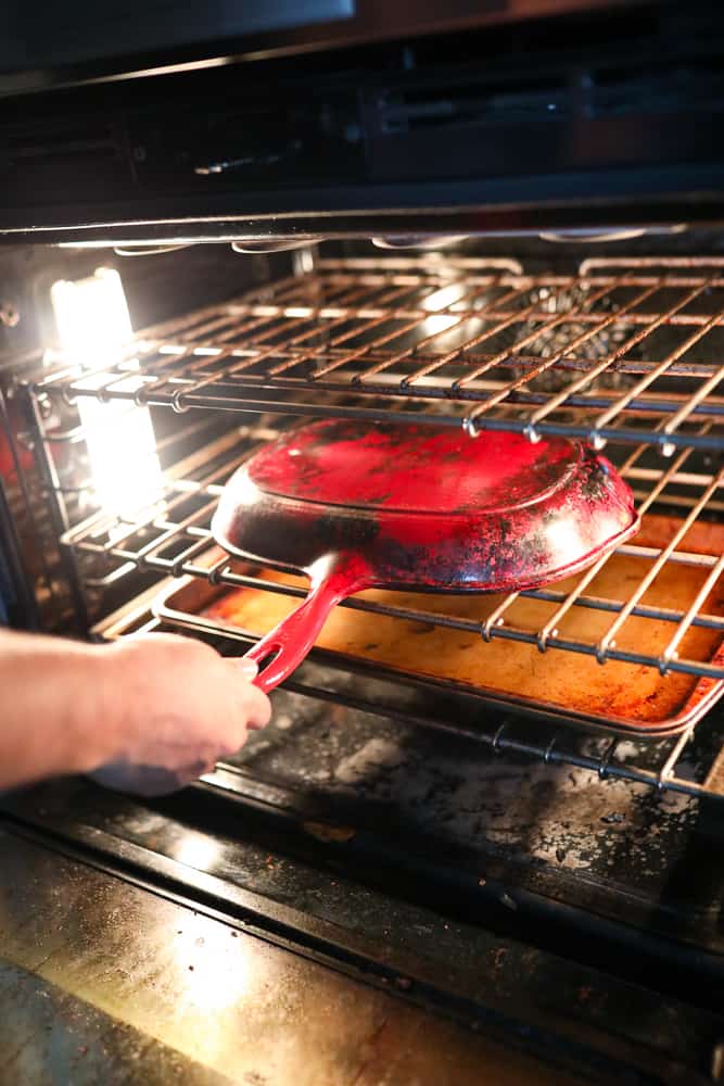 Placing an upside down cast iron pan in an oven.