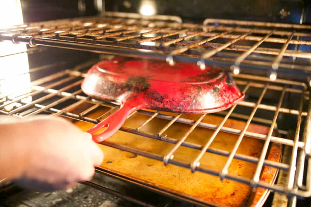 Placing an upside down cast iron pan in an oven.