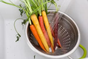 carrots in a colander being washed