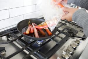 bag of carrots being emptied into pan