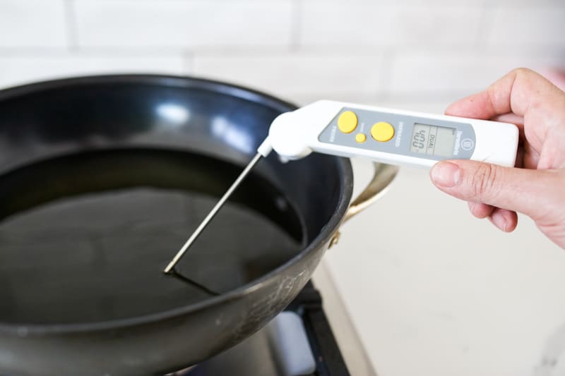 Wok with oil. Thermometer in the wok reading 400 degrees.