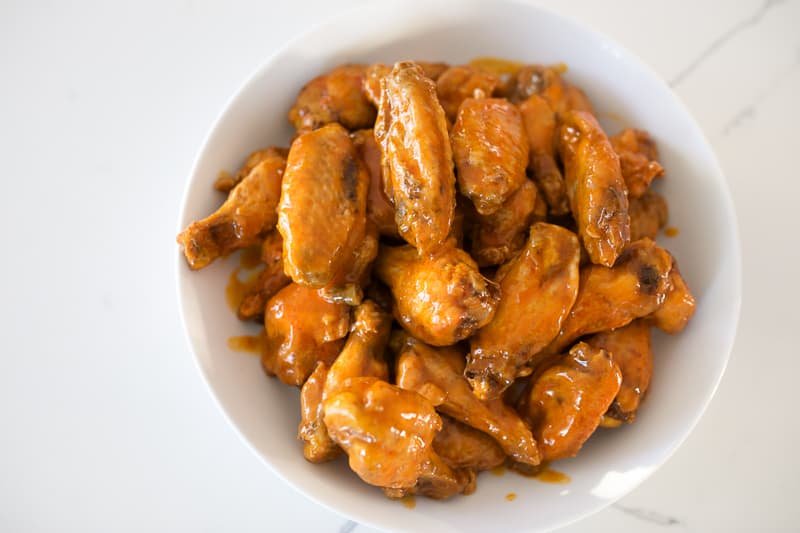 Chicken wings in a dish in a classic buffalo sauce. View from atop.