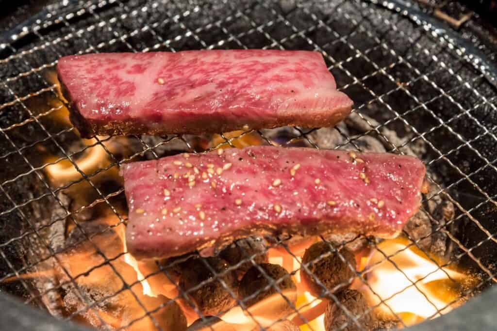 Two thin strips of Wagyu being cooked teppanyaki style.