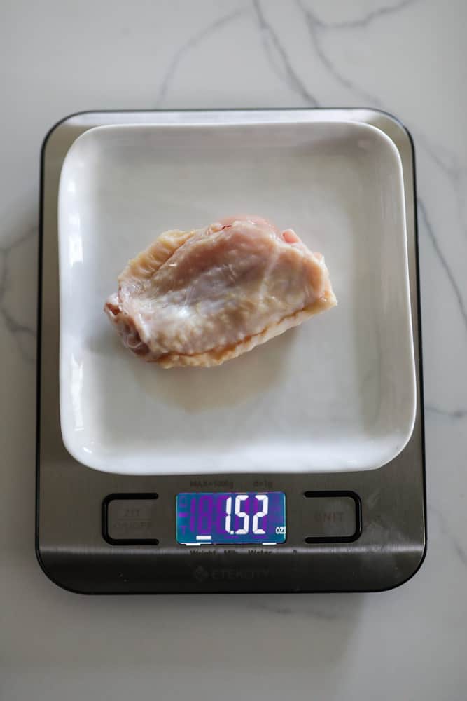 Chicken wingette being weighed on a scale. Scale reads 1 pounds 5 ounces.