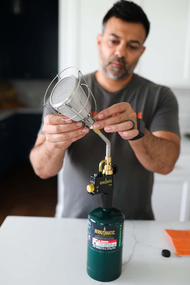 Fixing the Searzall atop the TS8000, which is attached to a propane tank, which is sitting on a counter.