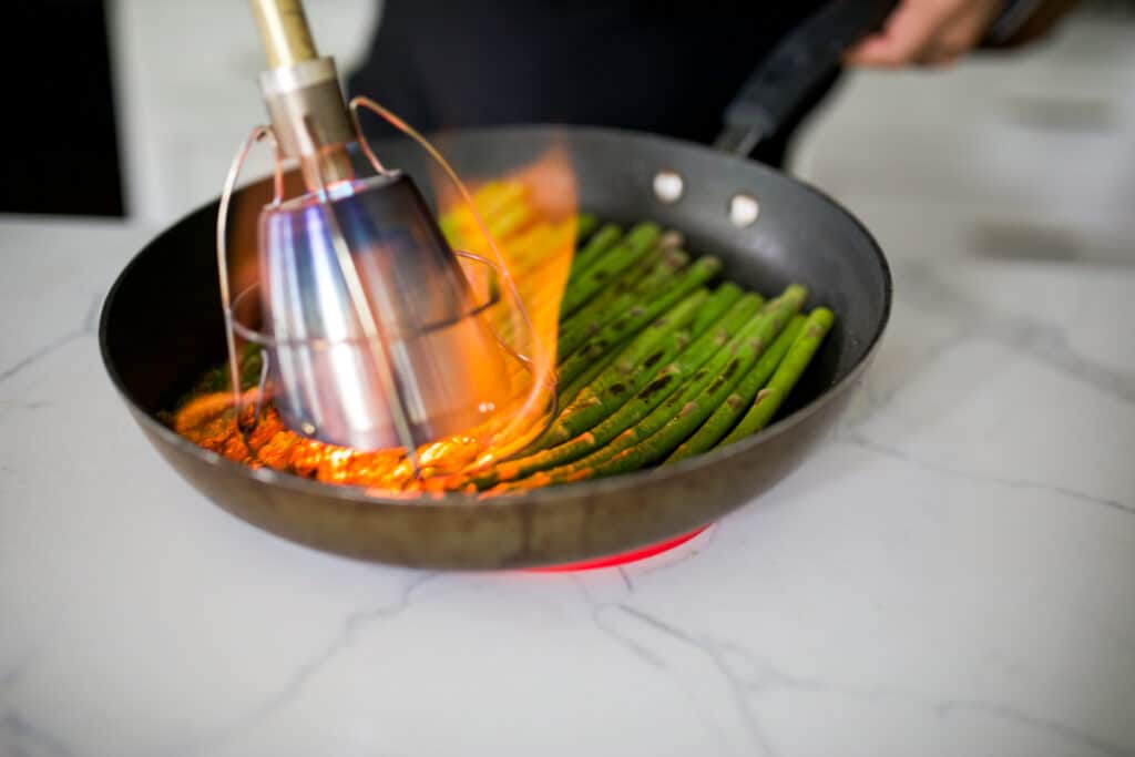Searing the asparagus with a Searzall torch attachment.