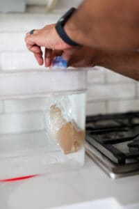 Submerged bag with chicken breast in sous vide bath.