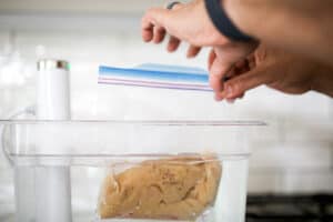 Sous vide bag with chicken being sealed with the water displacement method.