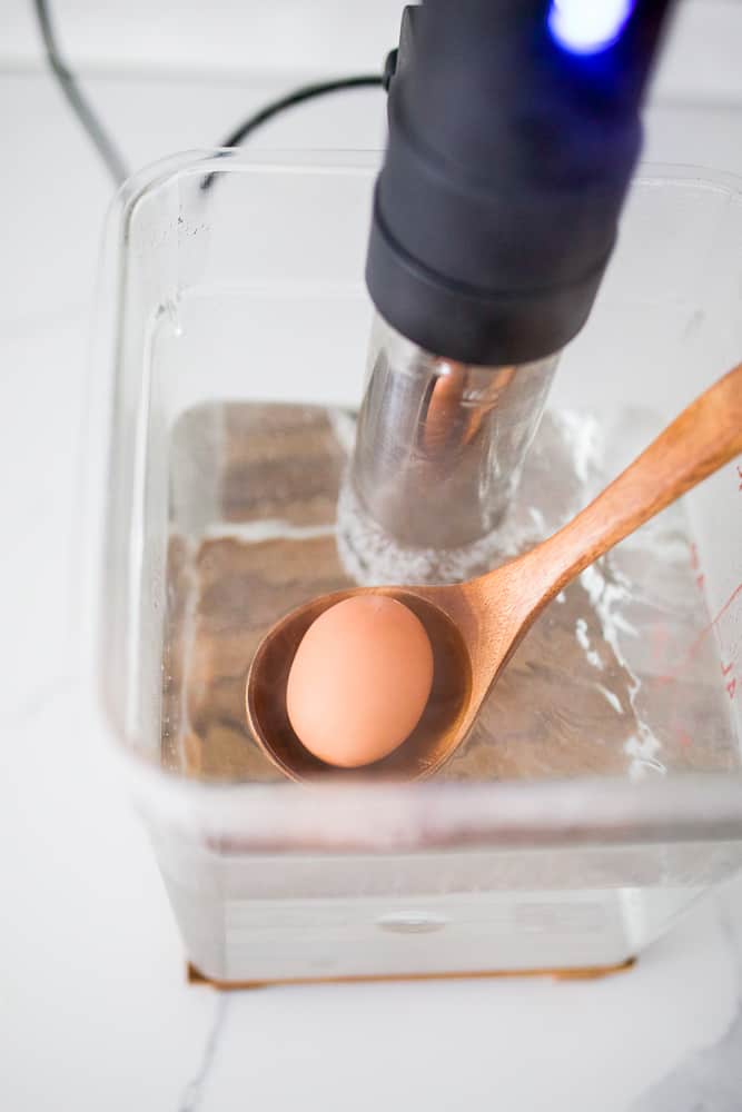 Egg being placed in a sous vide bath.