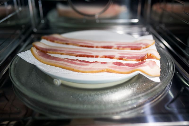 Bacon on a paper towel lined plate in the microwave. 