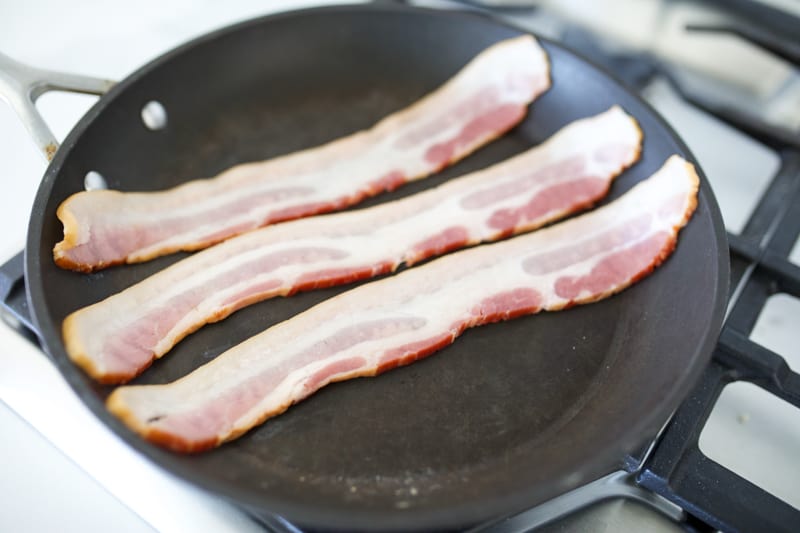 Bacon being defrosted in a skillet.