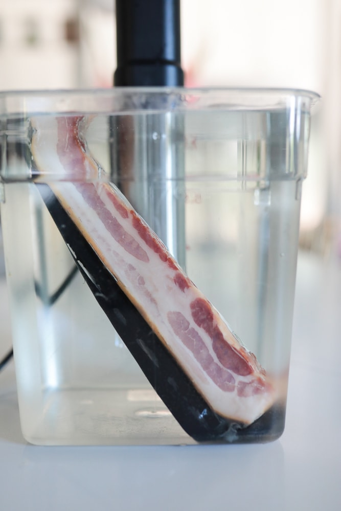Bacon package in sous vide cooker water bath.