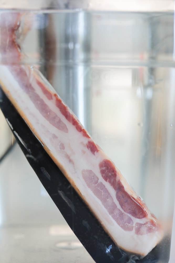 Bacon package in sous vide cooker water bath.